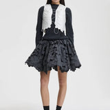 Front view of snow white breno vest on model wearing black dress and sneakers, against a white background.