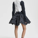 Back view of snow white breno vest on model wearing black dress and sneakers, against a white background.