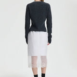 Back view of white bria skirt on model wearing grey sweater and black sneakers, against a white background.