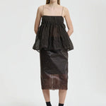 Front view of soil brown veronica top on model wearing brown skirt and sneakers with socks, against a white background.