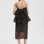 Back view of soil brown veronica top on model wearing brown skirt and sneakers with socks, against a white background.