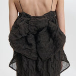 Back closeup view of soli brown veronica top on model wearing brown skirt, against a white background.
