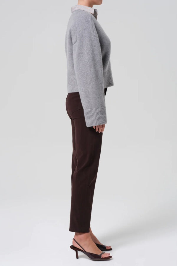 Side view of barrister caia pants on model wearing grey sweater and heels, against a white background.