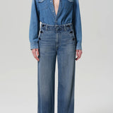 Front view of boardwalk trouser in jete on model wearing jean shirt and black heels, against a white background.