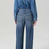 Back view of boardwalk jeans in jete on model wearing jean short and black heels, against a white background.