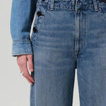Front closeup view of boardwalk trouser in jete on model wearing jean shirt, against a white background.