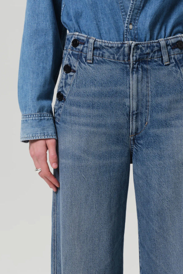 Front closeup view of boardwalk trouser in jete on model wearing jean shirt, against a white background.