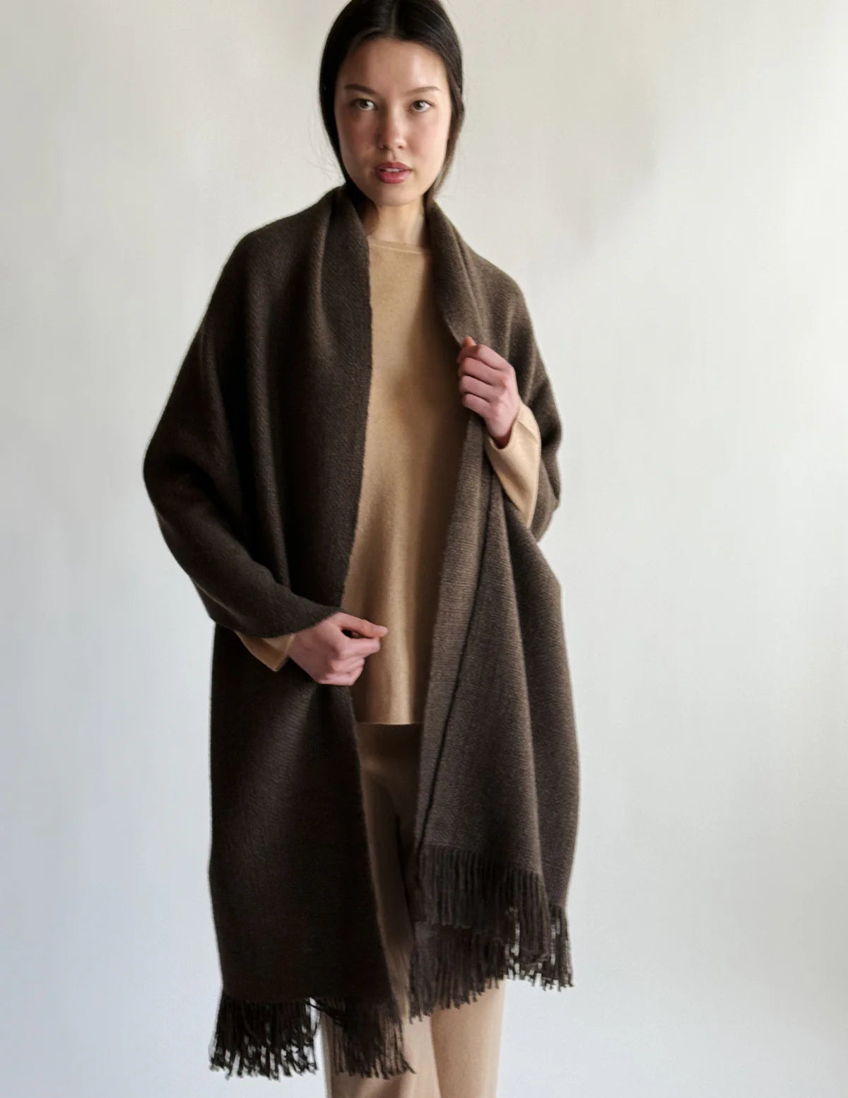 Front view of cappucino mongolian nubby stole on model wearing camel shirt and pants, against a white background.