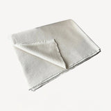 Front folded view of feather and jute reversible throw on white background, with no model shown.