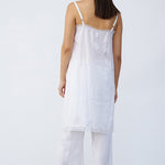 Back view of rice chemise slip on model wearing rice pants and natural sandals, against a white background.
