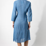 Back view of denim wrap dress on barefoot model, against a white background.