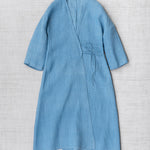 Front view of denim wrap dress on flat surface of a white background, with no model shown.