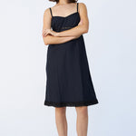 Front view of midnight kymber slip on model wearing natural sandals, against a white background.