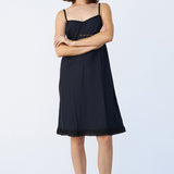 Front view of midnight kymber slip on model wearing natural sandals, against a white background.