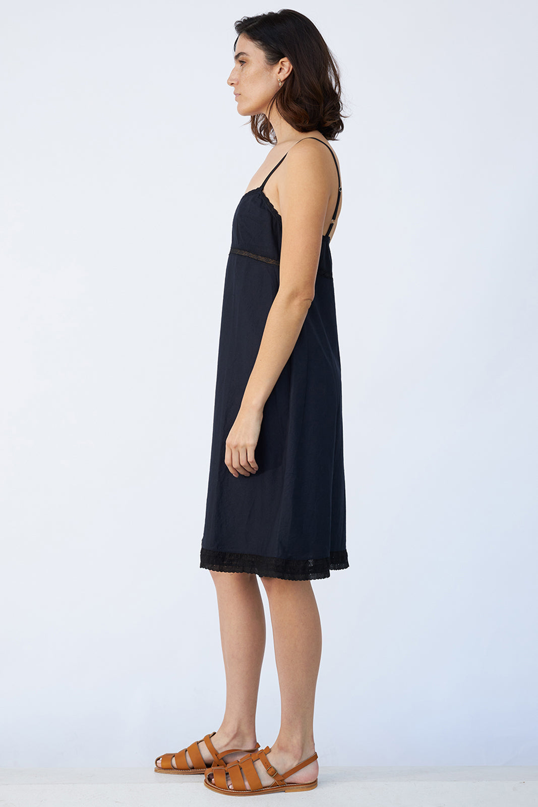 Side view of midnight kymber slip on model wearing natural sandals, against a white background.