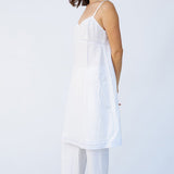 Side view of rice kymber slip on model wearing rice pants and natural sandals, against a white background.