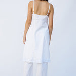 Back view of rice kymber slip on model wearing rice pants and natural sandals, against a white background.