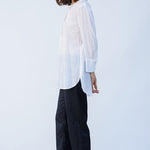 Side view of rice little subhash shirt on model wearing midnight pants and natural shoes, against a white background.