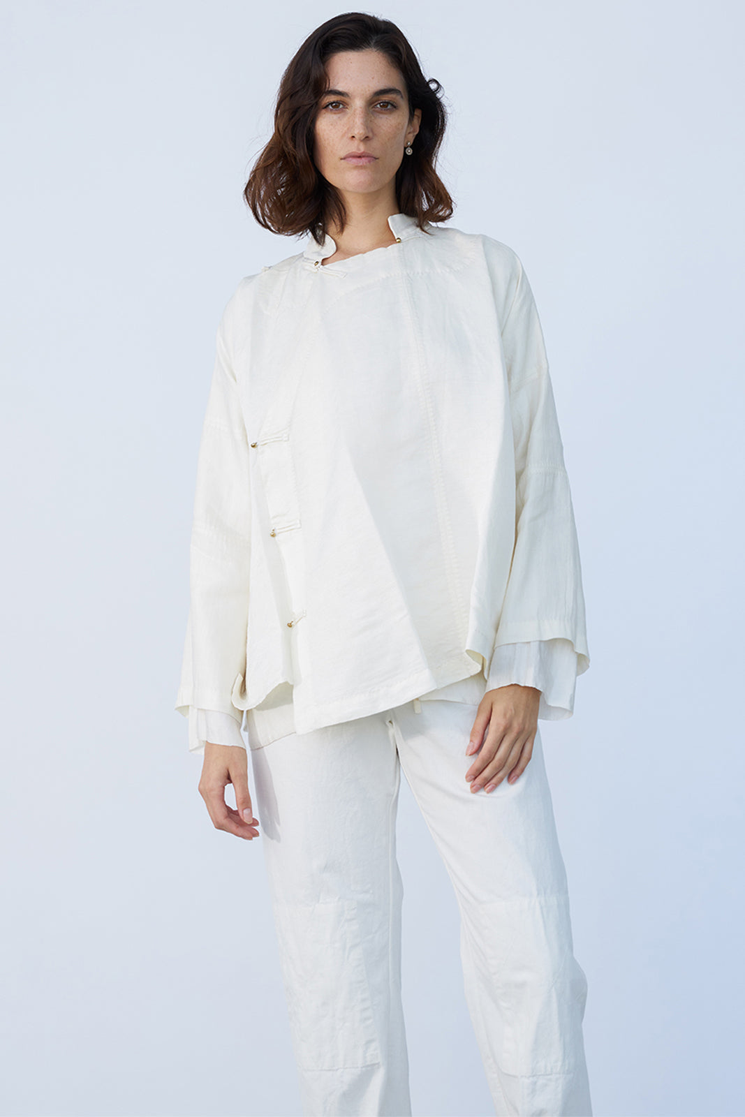 Front closeup view of rice mandarin jacket on model wearing rice pants, against a white background.