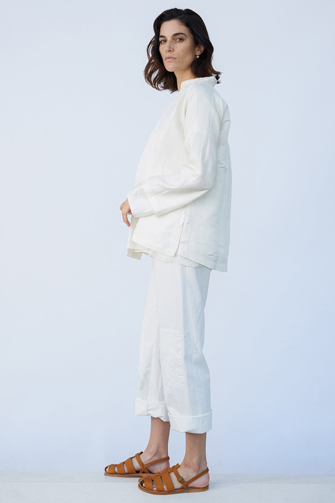 Side view of rice mandarin jacket on model wearing rice pants and natural sandals, against a white background.