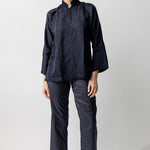 Front view of midnight mandarin jacket on model wearing midnight pants and natural sandals, against a white background.