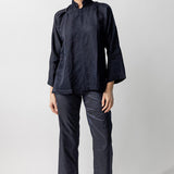 Front view of midnight mandarin jacket on model wearing midnight pants and natural sandals, against a white background.