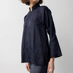 Alternate side view of midnight mandarin jacket on model wearing midnight pants, against a white background.