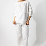 Front view of rice mary ellen mark blouse on model wearing rice pants, against a white background.