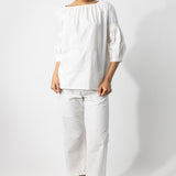 Front view of rice mary ellen mark blouse on model wearing rice pants, against a white background.