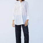 Front view of midnight pajama pant on model wearing white tunic and natural sandals, against a white background.