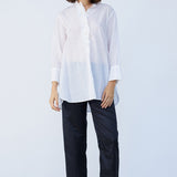 Front view of midnight pajama pant on model wearing white tunic and natural sandals, against a white background.