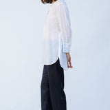 Side view of midnight pajama pant on model wearing white tunic and natural sandals, against a white background.