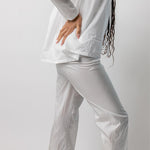 Side view of tint pajama pant on model wearing white top, against a white background.