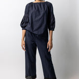Front view of midnight pants with lace on model wearing midnight top with natural sandals, against a white background.