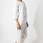 Side view of rice pants with lace on model wearing rice top, against a white background.