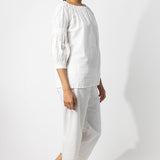 Side view of rice pants with lace on model wearing rice top, against a white background.