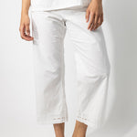 Front closeup view of rice pants with lace on model wearing a rice top, against a white background.