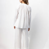 Back view of rice pants with velvet ribbon on model wearing rice top and natural sandals, against a white background