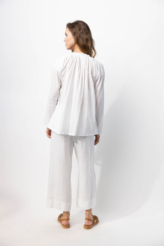 Back view of rice pants with velvet ribbon on model wearing rice top and natural sandals, against a white background
