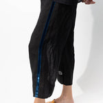 Side closeup view of ribbon detail of pants on model wearing midnight top and natural sandals, against a white background.