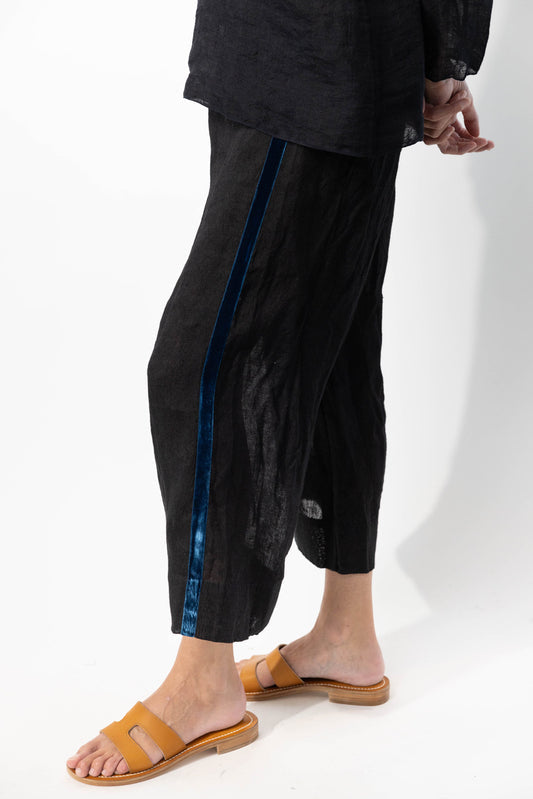 Side closeup view of ribbon detail of pants on model wearing midnight top and natural sandals, against a white background.