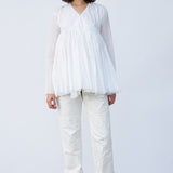 Front view of rice rabari jacket on model wearing white pants and natural sandals, against a white background.