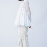 Side view of rice rabari jacket on model wearing white pants and natural sandals, against a white background.