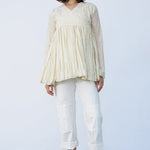 Front view of kora rabari jacket on model wearing white pants and natural sandals, against a white background.