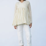 Front view of kora rabari jacket on model wearing white pants and natural sandals, against a white background.