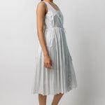 Side view of tint rajasthani dress on model wearing natural sandals, against a white background.