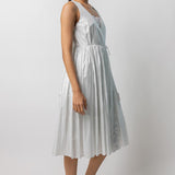 Side view of tint rajasthani dress on model wearing natural sandals, against a white background.