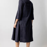 Back view of midnight short tule dress on model wearing natural sandals, against a white background.