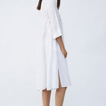 Side view of rice short tule dress on model wearing natural sandals, against a white background.