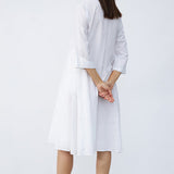 Back view of rice short tule dress on model wearing natural sandals, against a white background.